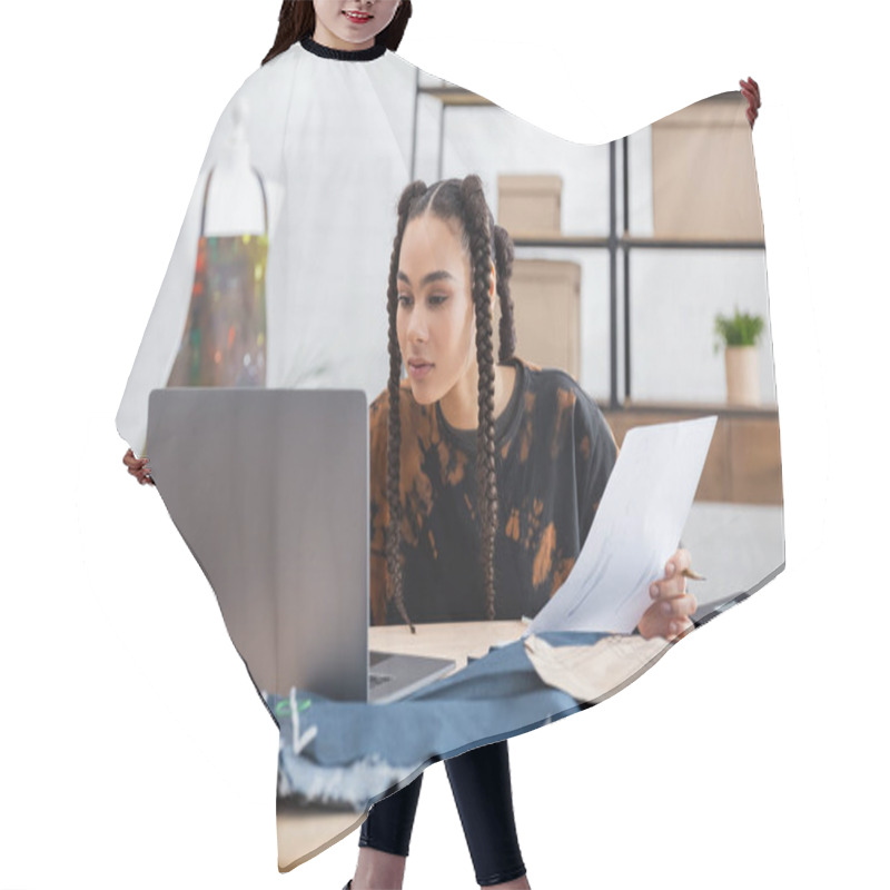 Personality  African American Craftswoman Holding Sketch Near Laptop And Cloth In Workshop  Hair Cutting Cape