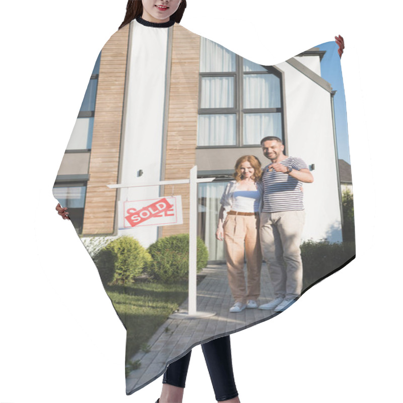 Personality  Full Length Of Happy Couple With Key Hugging And Looking At Camera While Standing Near Modern House And Sign With Sold Lettering Hair Cutting Cape