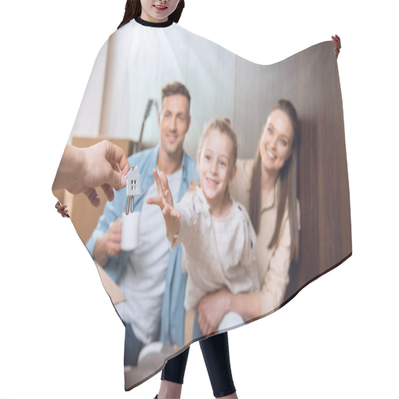 Personality  Selective Focus Of House Shaped Key Chain With Smiling Kid Sitting Near Parents On Background Hair Cutting Cape