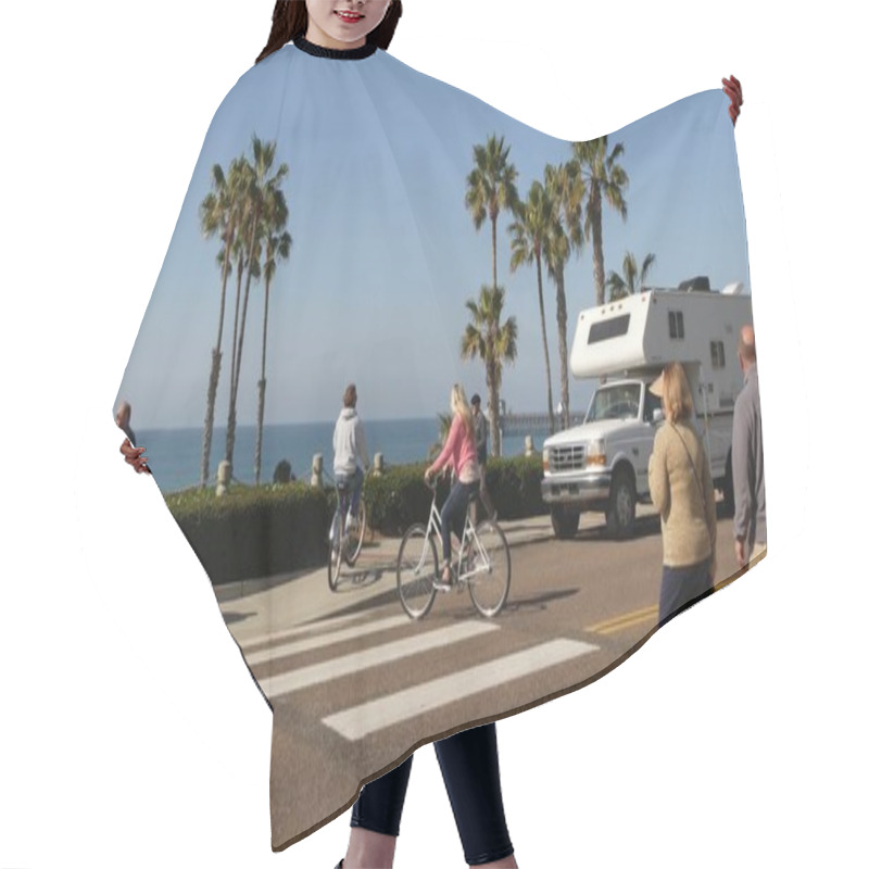 Personality  Oceanside, California USA - 8 Feb 2020: Motorhome, People Riding Bikes On Ped Crossing Zebra, Waterfront Road. Pacific Ocean Tropical Beach Tourist Resort. Palm Trees On Beachfront Street Sunny Day. Hair Cutting Cape