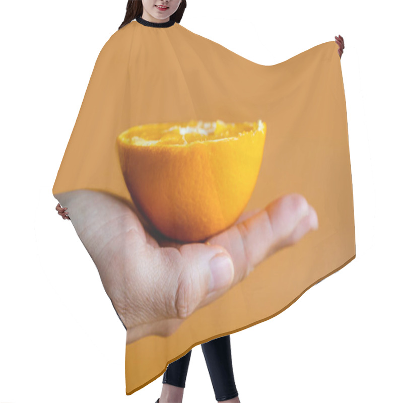 Personality  Woman's Hands Holding Halves Of Orange On Yellow Orange Background. Hair Cutting Cape