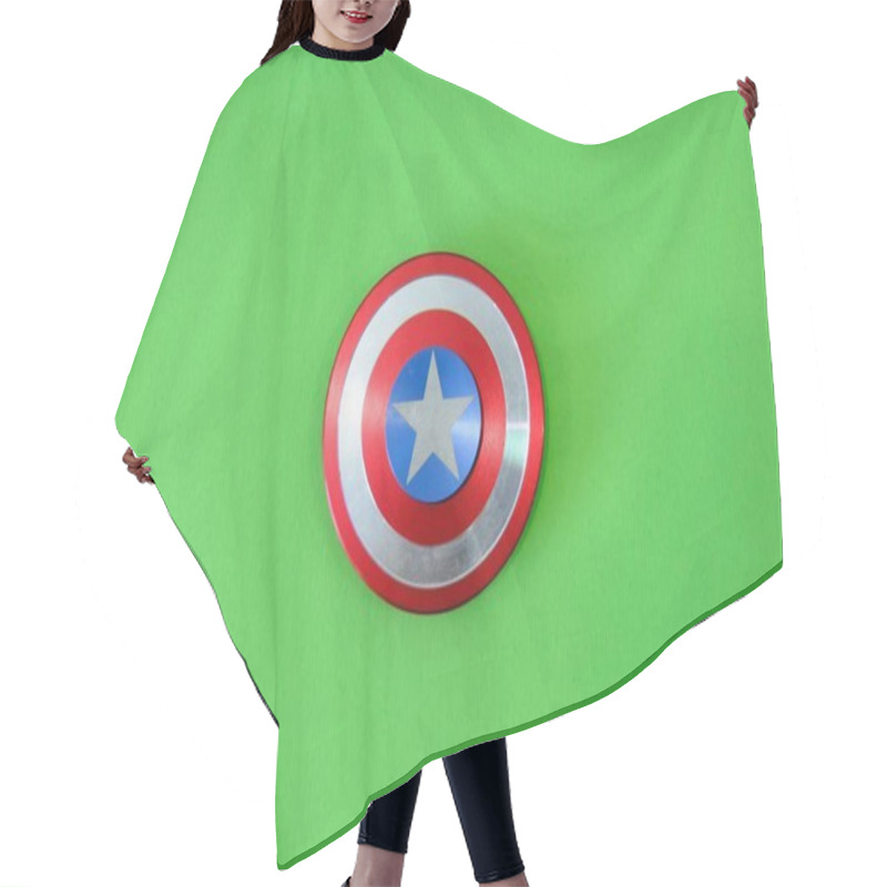 Personality  Round Badge Captain America, Fiji Spinner Toy On A Green Background. High Quality Photo Hair Cutting Cape