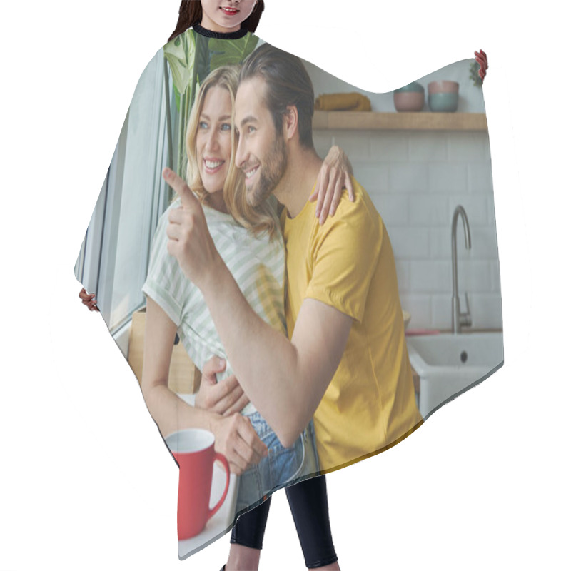 Personality  Beautiful Young Couple Looking Through A Window And Smiling While Standing At The Kitchen Hair Cutting Cape