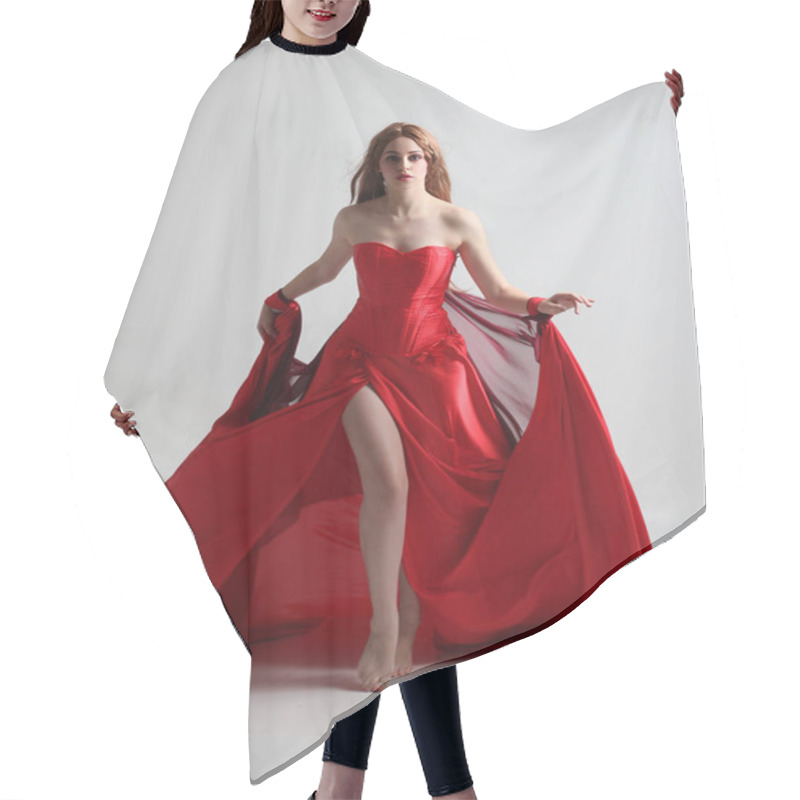 Personality  Full Length Portrait Of A  Girl Wearing A Long Red Silk Gown, Standing Pose On A Grey Studio Background. Hair Cutting Cape