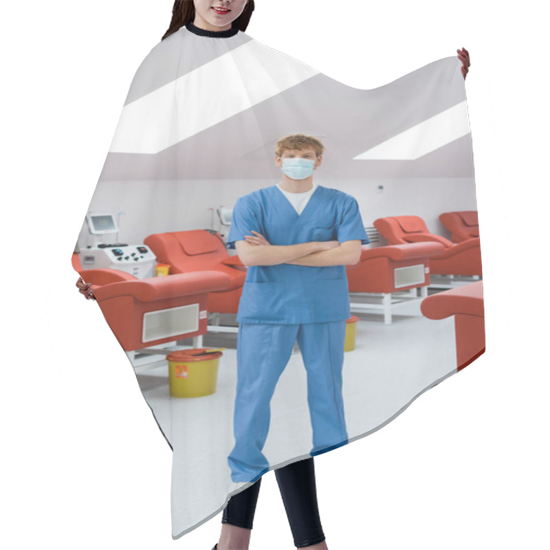 Personality  Full Length Of Redhead Doctor In Blue Uniform And Medical Mask Standing With Folded Arms Near Medical Chairs, Transfusion Machines And Trash Buckets In Modern Hospital Hair Cutting Cape