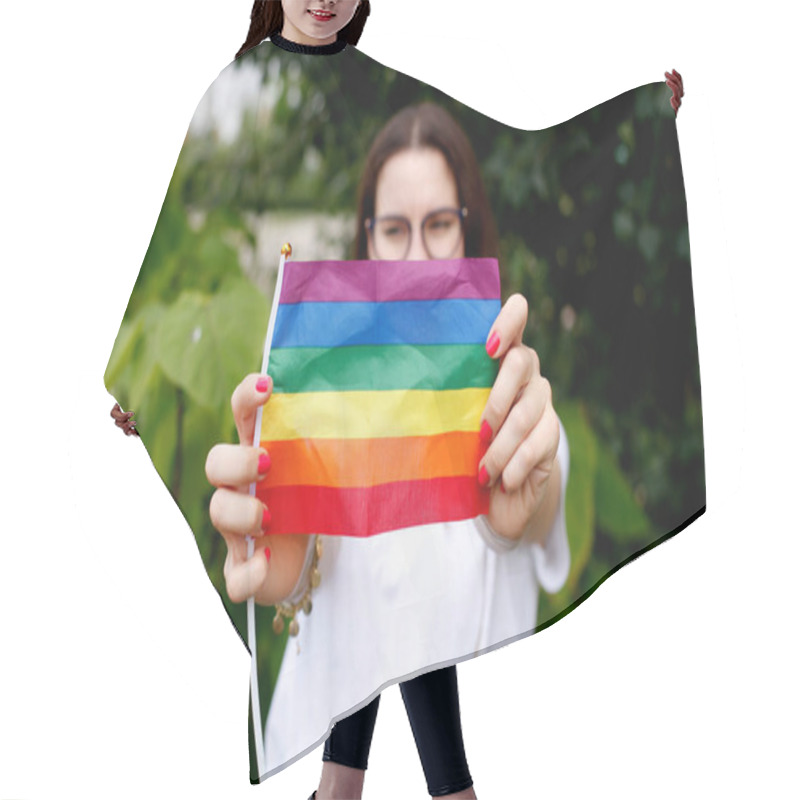 Personality  The Concept Of LGBT Rights, The Hand Holds The LGBT Flag, Against The Backdrop Of Nature. A Young Girl With A LGBT Flag In Nature.  Hair Cutting Cape