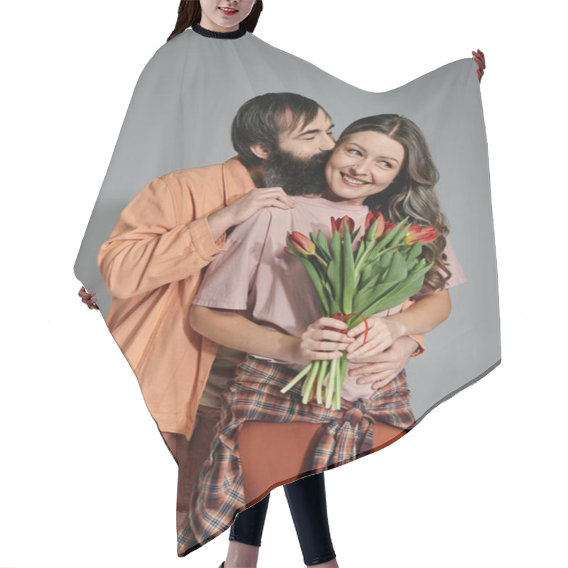 Personality  A Man And Woman In Sophisticated Attire Pose Together In A Studio Setting. The Man Kisses The Woman On The Cheek, And She Holds A Bouquet Of Red Tulips. Hair Cutting Cape