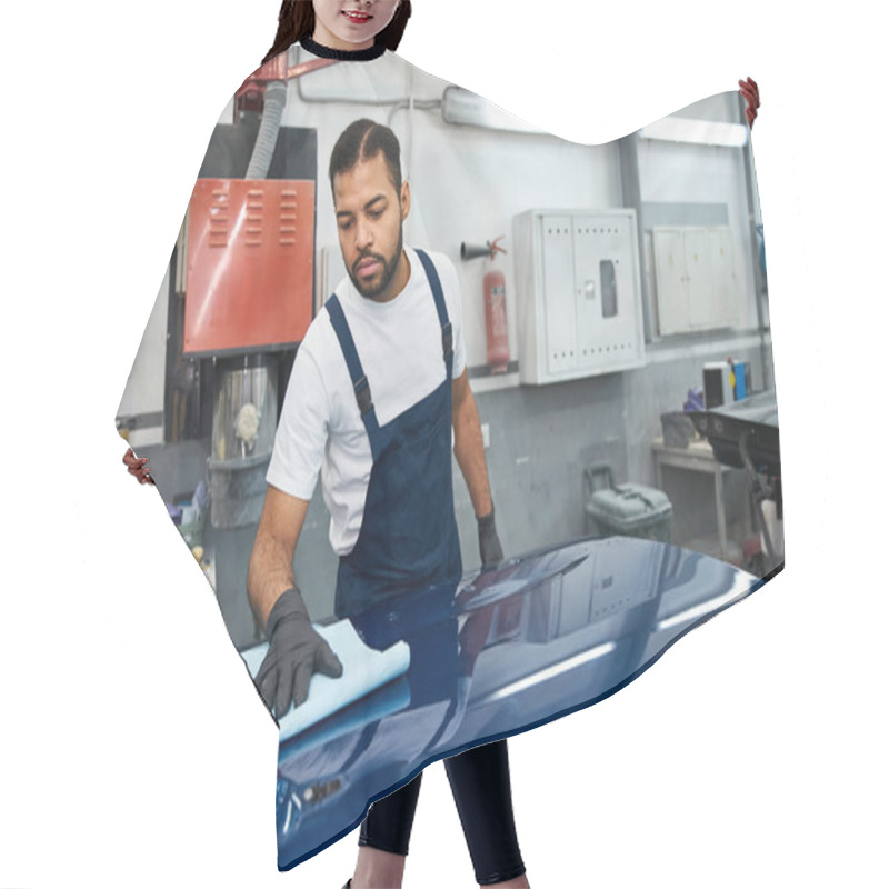 Personality  Young Mechanic Focuses On Cleaning A Car Hood With A Cloth In A Busy Repair Shop. Hair Cutting Cape