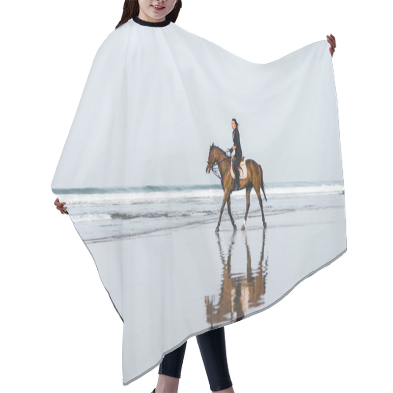 Personality  Distant View Of Woman Riding Horse On Sandy Beach With Ocean Behind Hair Cutting Cape