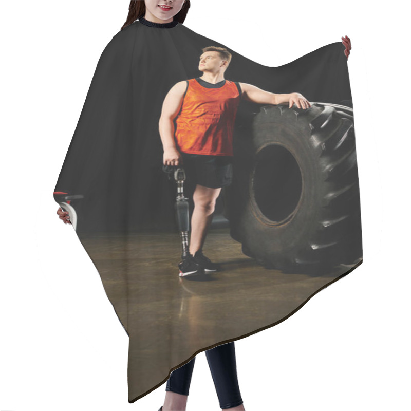 Personality  A Man With A Prosthetic Leg Standing Next To A Massive Tire In A Gym. Hair Cutting Cape