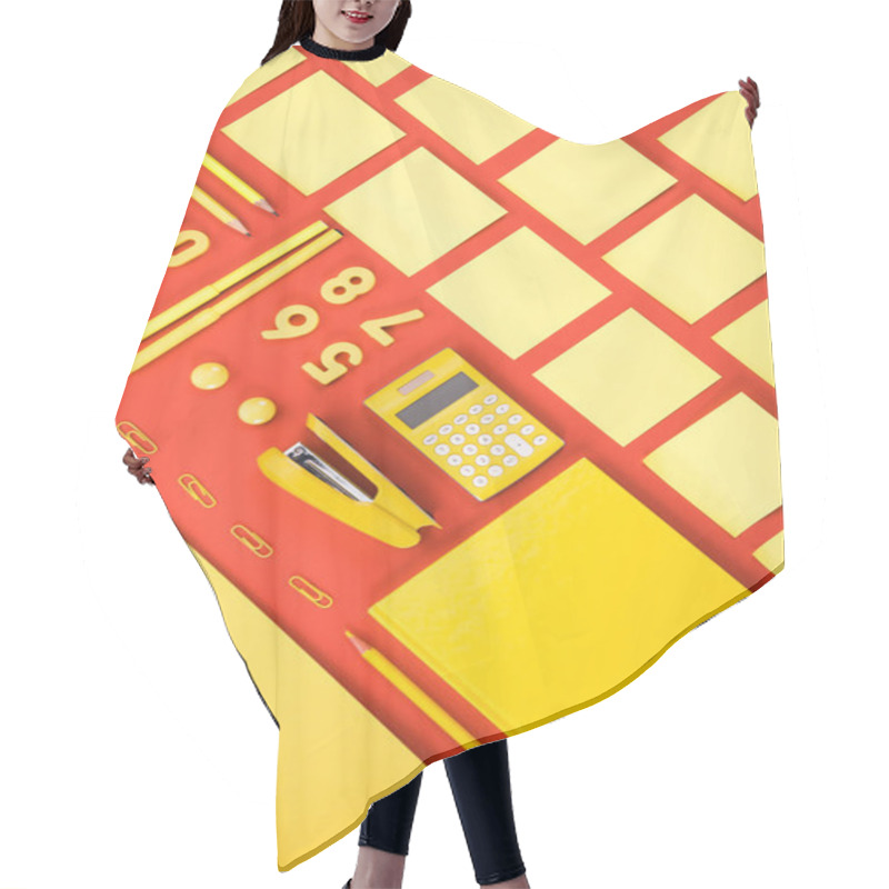 Personality  Flat Lay With Arranged Yellow Schooling Supplies In Rows On Red Hair Cutting Cape