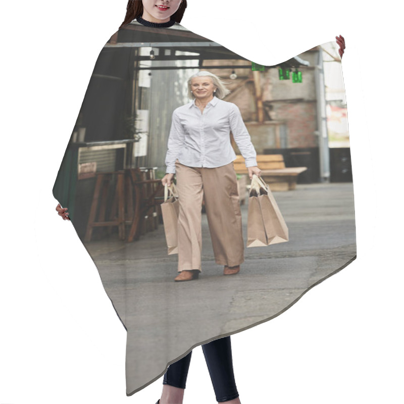 Personality  A Beautiful Mature Woman Enjoys Her Stroll, Carrying Shopping Bags Down A Charming Market Street. Hair Cutting Cape