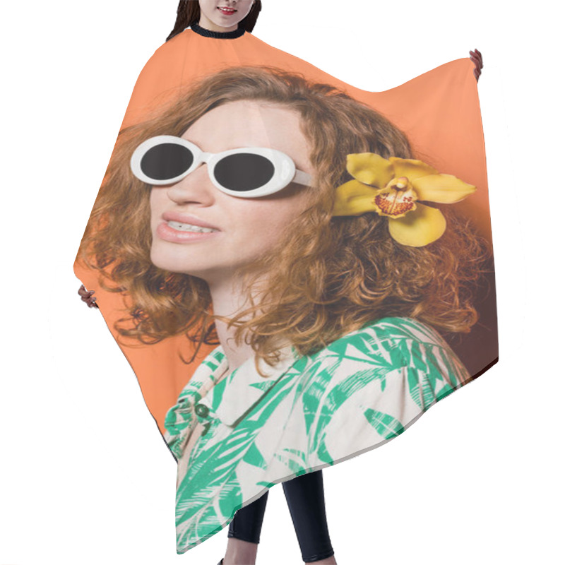 Personality  Young Trendy Red Haired Woman With Sunglasses, Blouse With Floral Print And Orchid Flower In Hair Smiling While Standing On Orange Background, Summer Casual And Fashion Concept, Youth Culture Hair Cutting Cape