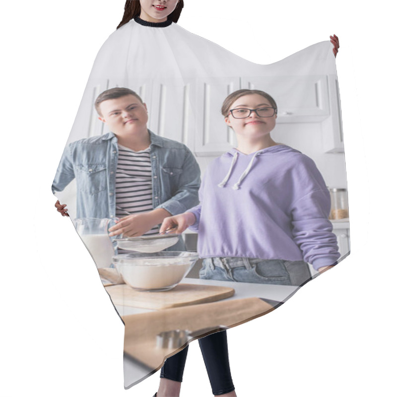 Personality  Teenagers In Down Syndrome Looking At Camera Near Food In Kitchen  Hair Cutting Cape