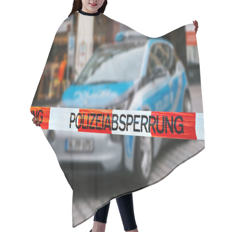 Personality  Police Tape At The Crime Scene. Focus On The Police Tape, A Police Car On Blurred Background. German Police. Hair Cutting Cape