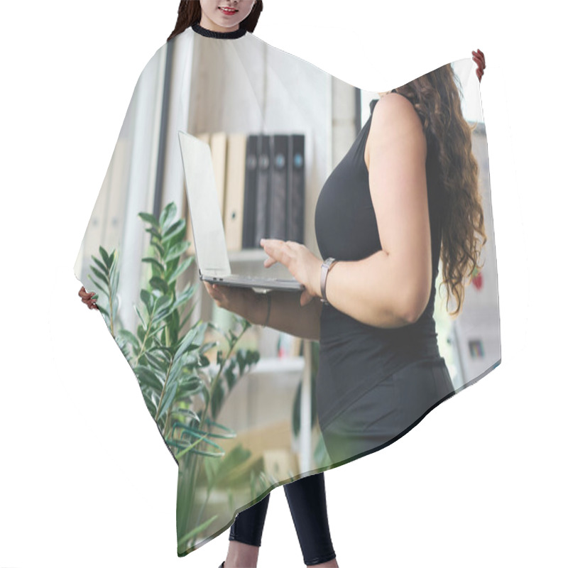 Personality  A Professional Plus Size Woman Stands Confidently, Working On Her Laptop In A Vibrant Office Atmosphere Enriched By Plants. Hair Cutting Cape