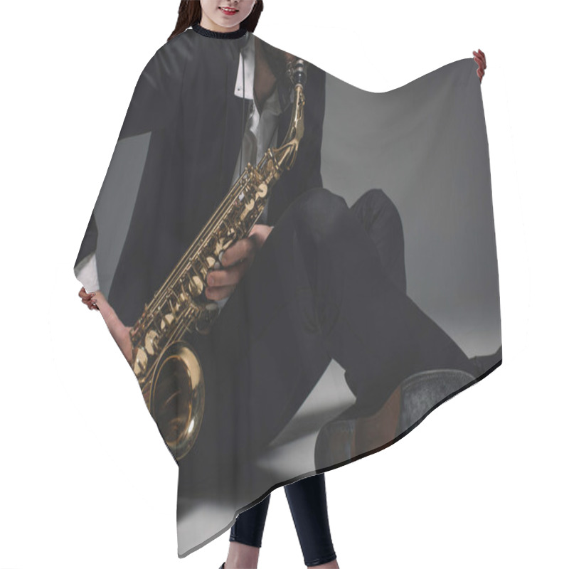 Personality  Cropped Shot Of Musician Playing Saxophone While Sitting On Floor Hair Cutting Cape