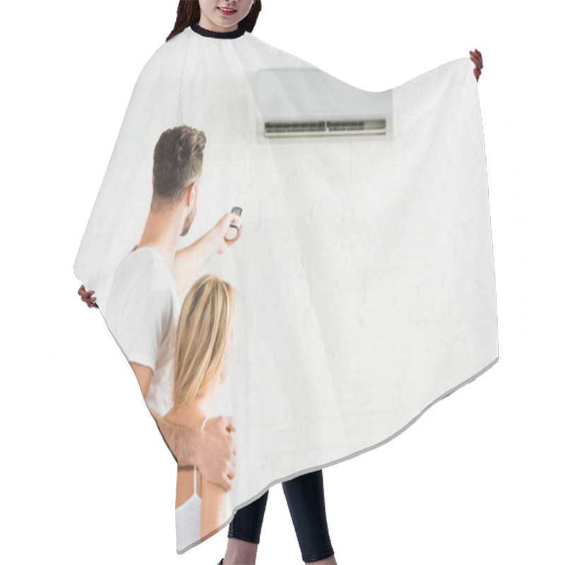 Personality  Back View Of Couple With Remote Control Suffering From Heat Under Air Conditioner At Home Hair Cutting Cape