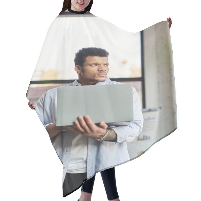 Personality  Man In A Casual Outfit Stands Holding A Laptop, Lost In Thought Amid A Bright Office Setting. Hair Cutting Cape