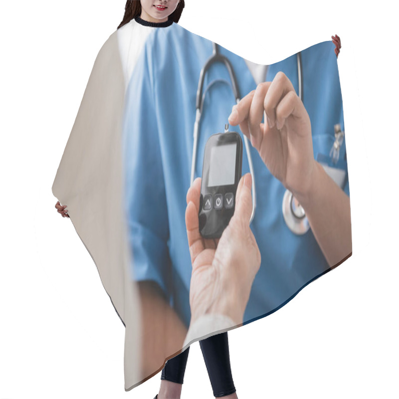 Personality  Cropped View Of Multiracial Nurse Pointing With Finger At Glucometer With Test Strip Near Senior Woman Hair Cutting Cape