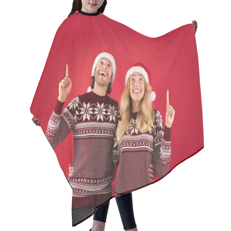 Personality  Christmas Sale. Happy Millennial Couple In Santa Hats Pointing Upwards On Red Background Hair Cutting Cape