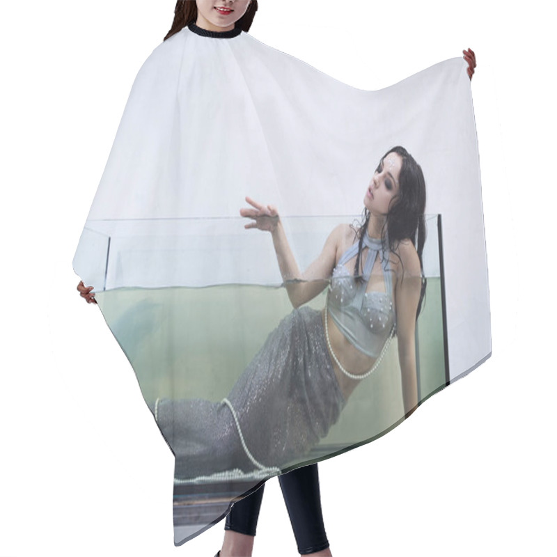 Personality  A Young Woman With Long, Dark Hair Dressed As A Mermaid, Lies In A Large Glass Tank Filled With Water. Hair Cutting Cape