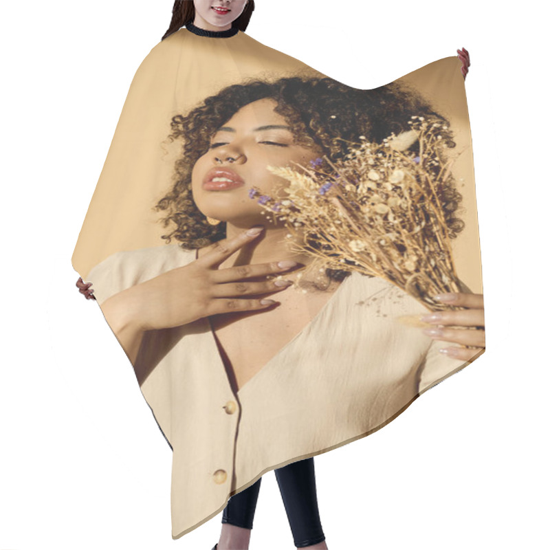 Personality  A Beautiful Young African American Woman With Curly Hair Holding A Bunch Of Dried Flowers In A Studio Setting. Hair Cutting Cape