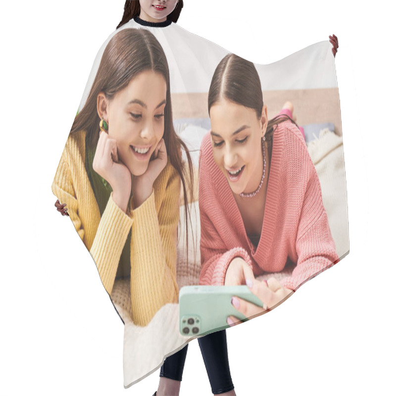 Personality  Two Pretty Teenage Girls In Casual Attire Lying On A Bed, Engrossed In A Screen, Sharing A Cozy Moment Together. Hair Cutting Cape