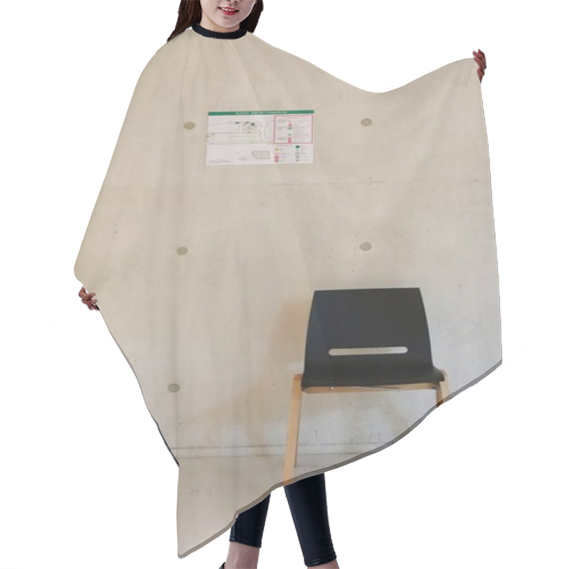 Personality  Minimalist Black Chair Against Concrete Wall With Emergency Exit Map. High Quality Photo Hair Cutting Cape