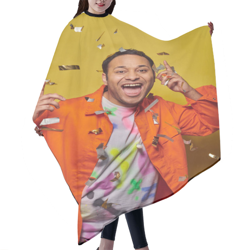 Personality  Excited Indian Man In Orange Jacket Smiling Near Falling Confetti On Yellow Backdrop, Party Concept Hair Cutting Cape