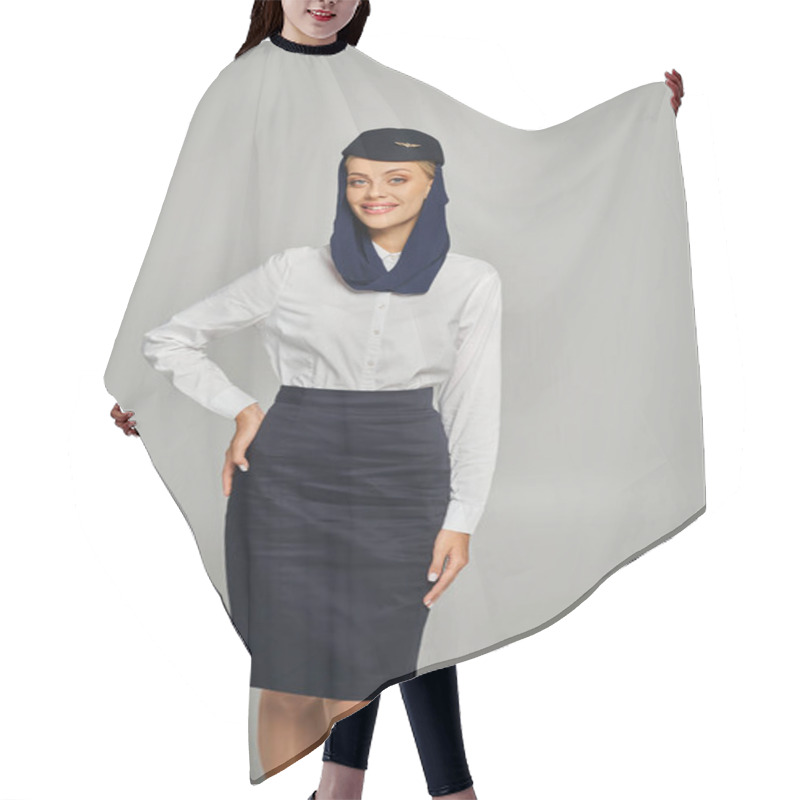 Personality  Stylish And Cheerful Stewardess In Arabian Airlines Uniform Posing With Hand On Hip On Grey Hair Cutting Cape