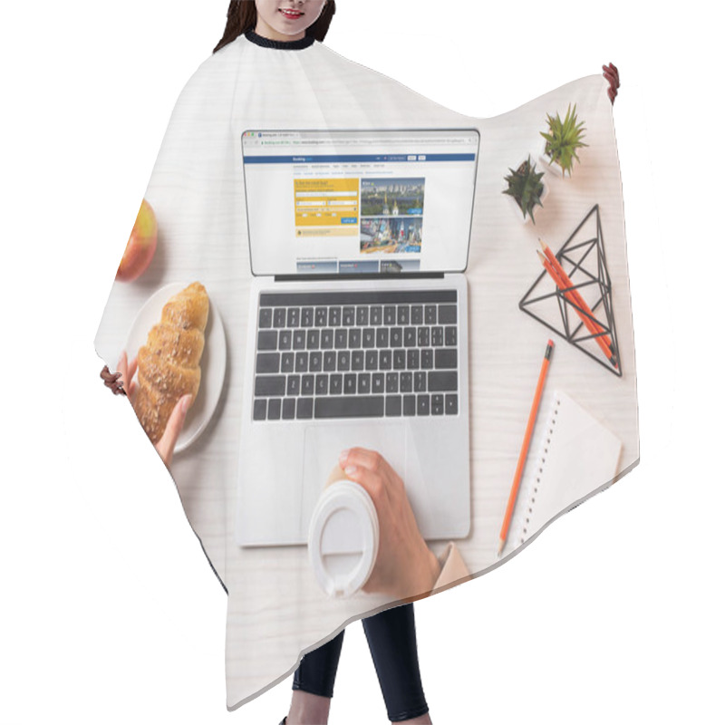 Personality  Cropped Shot Of Businesswoman Holding Disposable Coffee Cup And Croissant While Using Laptop With Booking Website  Hair Cutting Cape