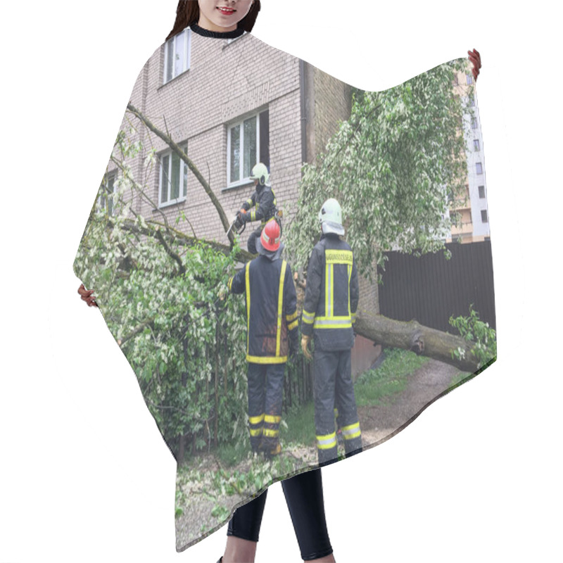 Personality  Latvia, Riga. Workers Using A Chainsaw Clear The Street From A Fallen Tree After A Storm. Hair Cutting Cape