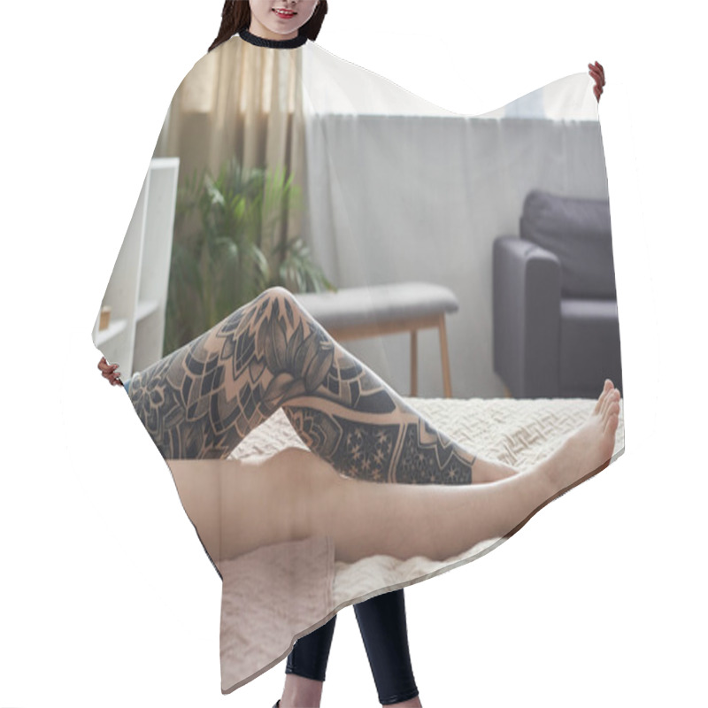 Personality  A Woman With A Leg Tattoo Relaxes On A Bed In A Modern Apartment, Enjoying A Cozy Weekend At Home. Hair Cutting Cape