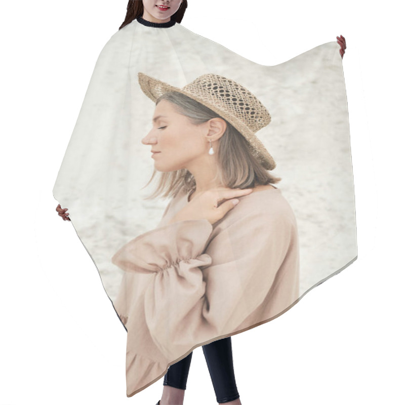 Personality  Stylish Girl In Trendy Summer Linen Dress Straw Hat Posing On The Sand. Boho Style. Hair Cutting Cape