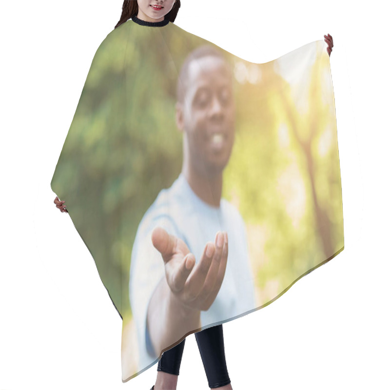 Personality  Cheerful black man reach his hand at camera hair cutting cape