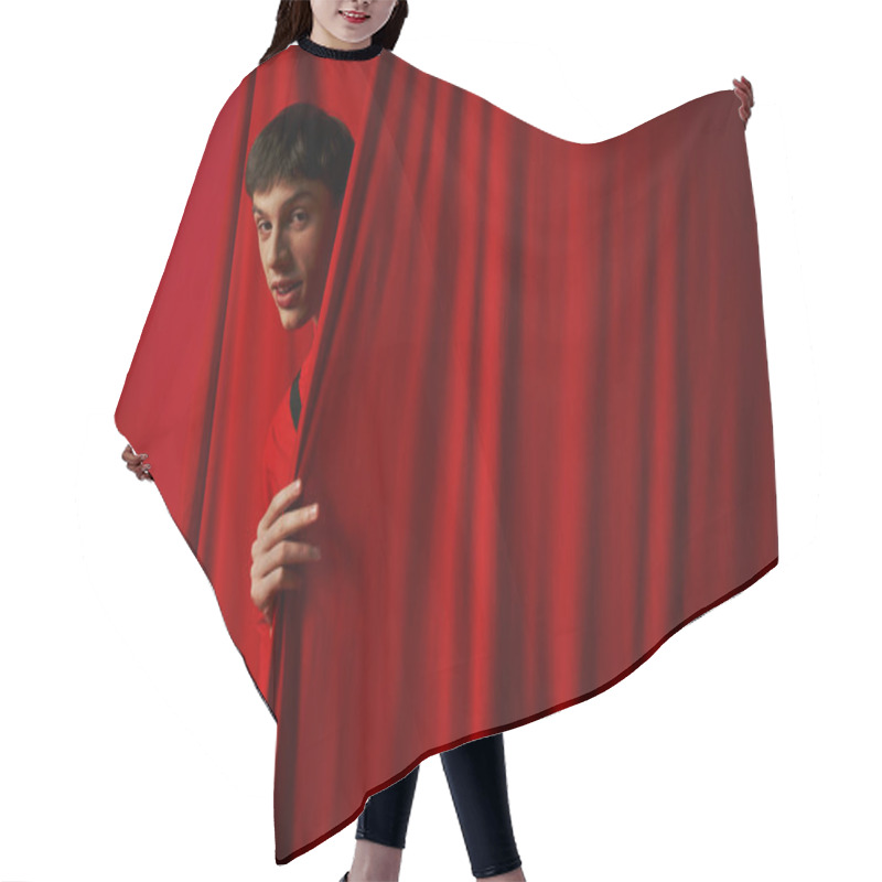 Personality  Playful Young Man In Vibrant Shirt Hiding Behind Red Curtain While Playing Hide And Seek, Peeking Hair Cutting Cape