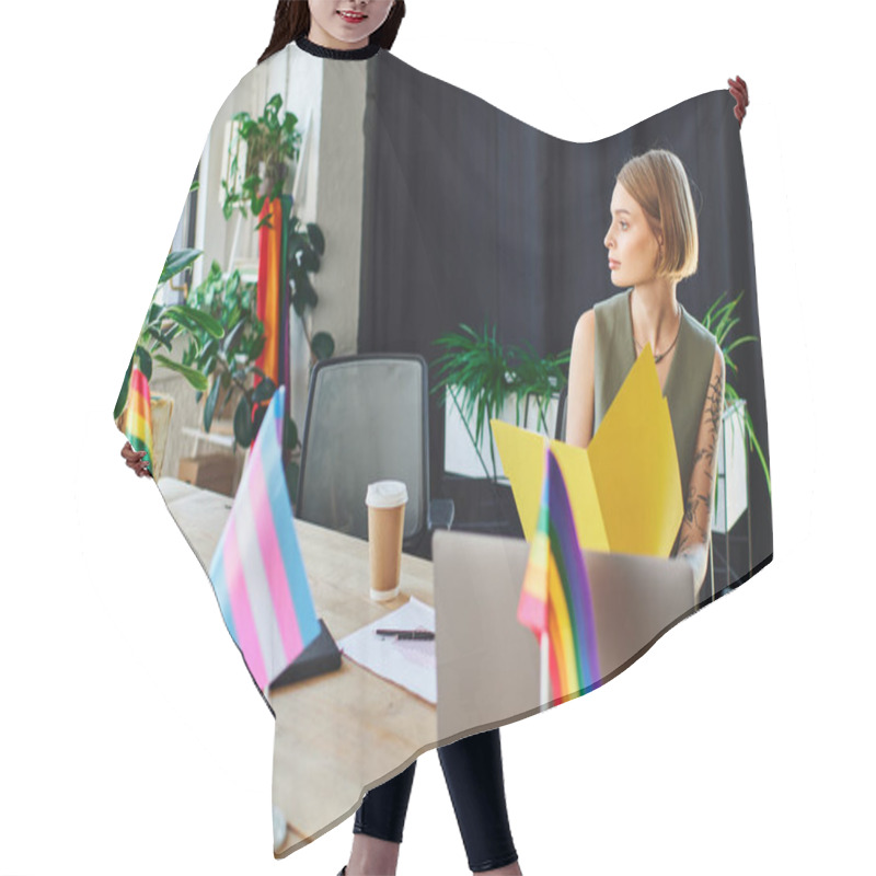 Personality  A Person Sits Thoughtfully At A Conference Table Surrounded By Pride Flags And Greenery. Hair Cutting Cape