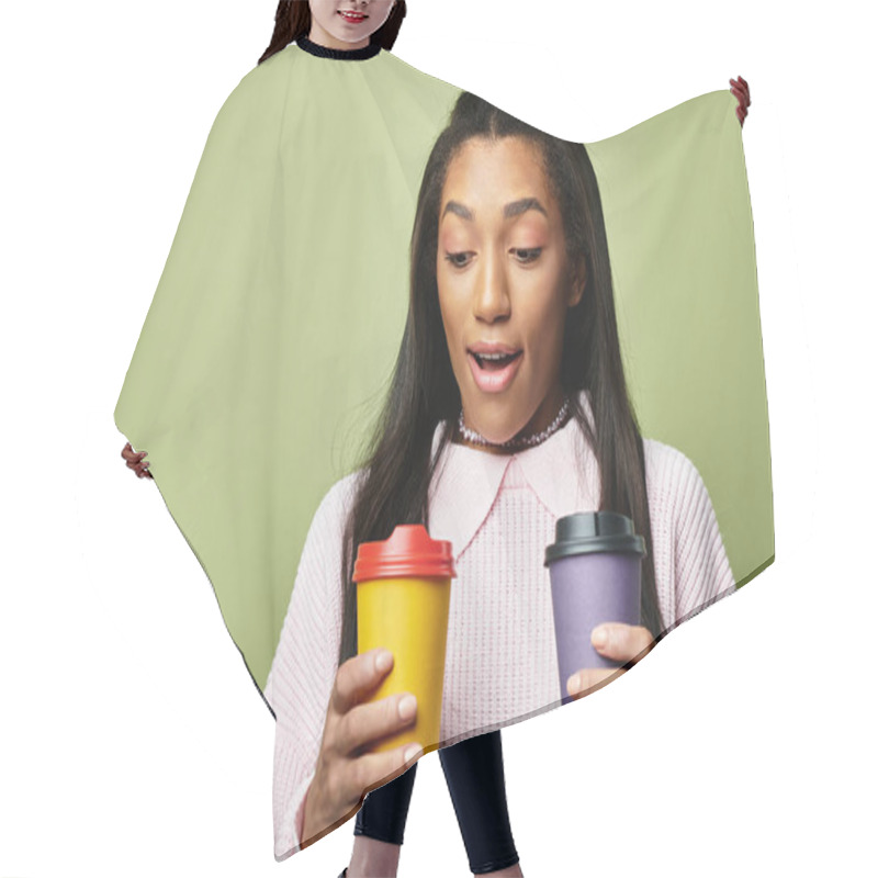 Personality  A Young Woman Warmly Dressed Smiles In Delight As She Holds Two Colorful Cups Of Coffee. Hair Cutting Cape