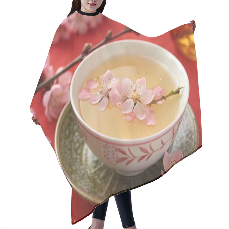 Personality  A High-resolution Photograph Showcasing A Traditional East Asian-style Tea With A Light, Translucent Broth And Delicate Pink Flower Petals, Including Small Blossoms With Intricate Yellow Stamens, Adorning The Surface. The Setting Is A Festive One, Wi Hair Cutting Cape