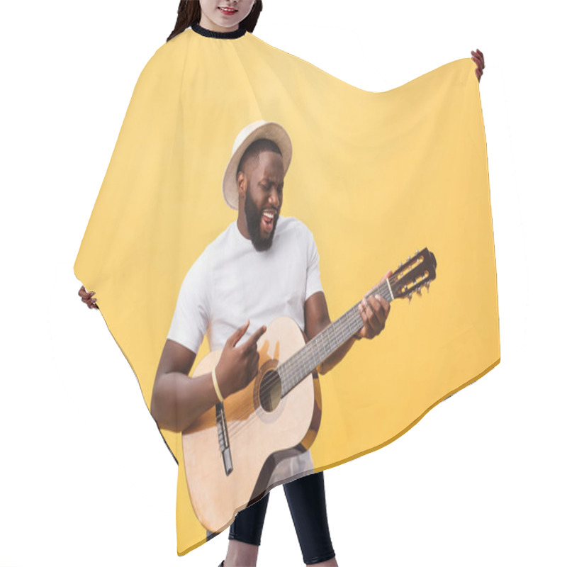 Personality  Muscular Black Man Playing Guitar, Wearing Jeans And White Tank-top. Isolate Over Yellow Background. Hair Cutting Cape