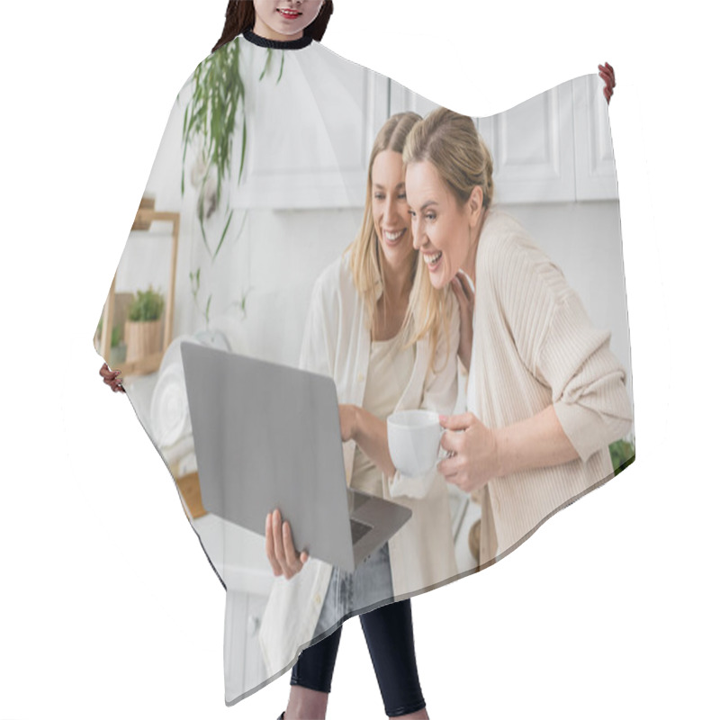 Personality  Two Cheerful Sisters Looking At Laptop And Smiling Sincerely Holding Tea Cup, Family Bonding Hair Cutting Cape