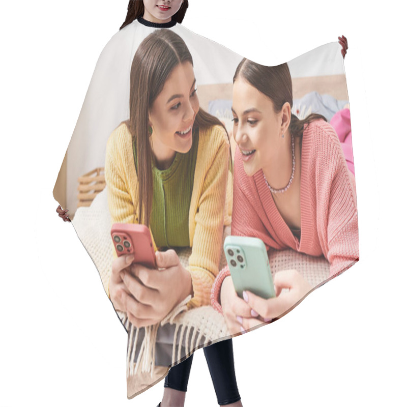 Personality  Two Young Women In Casual Attire Lounging On A Bed, Engrossed In Their Cell Phones. Hair Cutting Cape