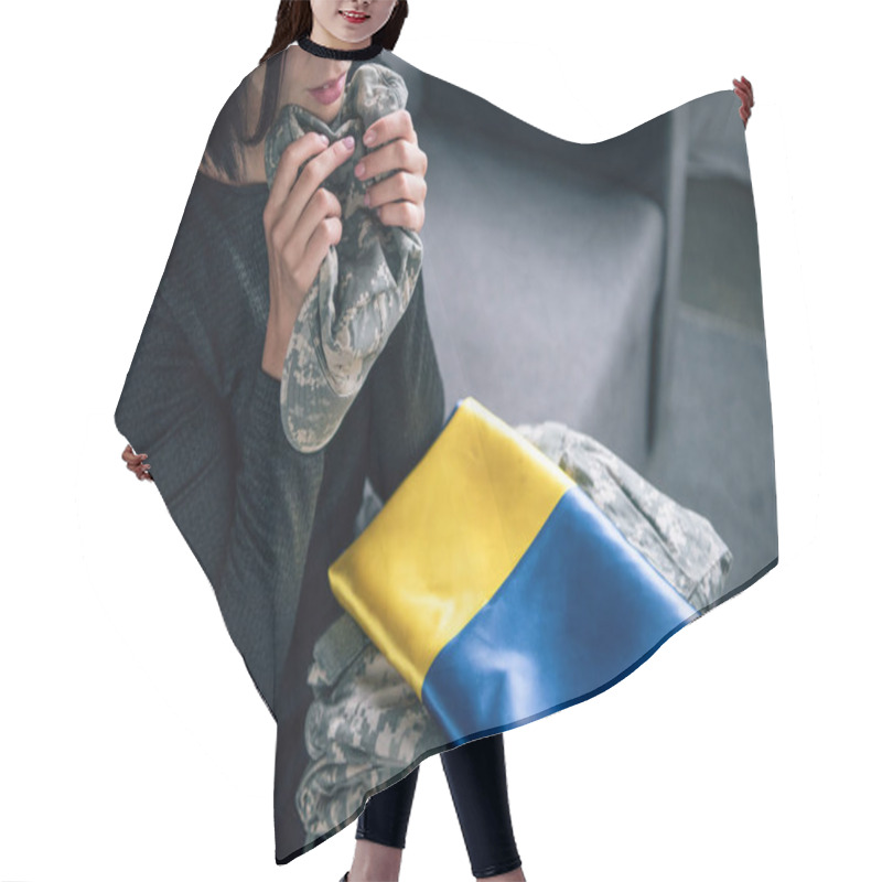 Personality  Cropped View Of Upset Woman Holding Military Clothing And Ukrainian Flag At Home Hair Cutting Cape