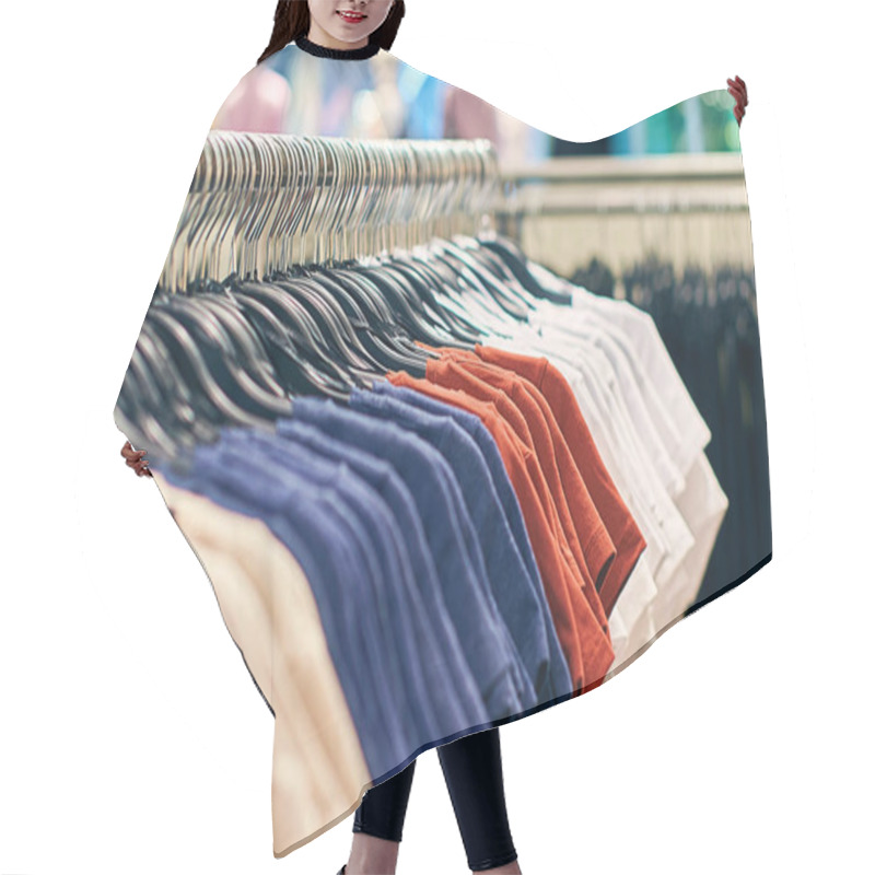 Personality  Interior Of Fashion Clothes Store With T-shirts On Hangers In Red, Blue And Other Colors. Hair Cutting Cape