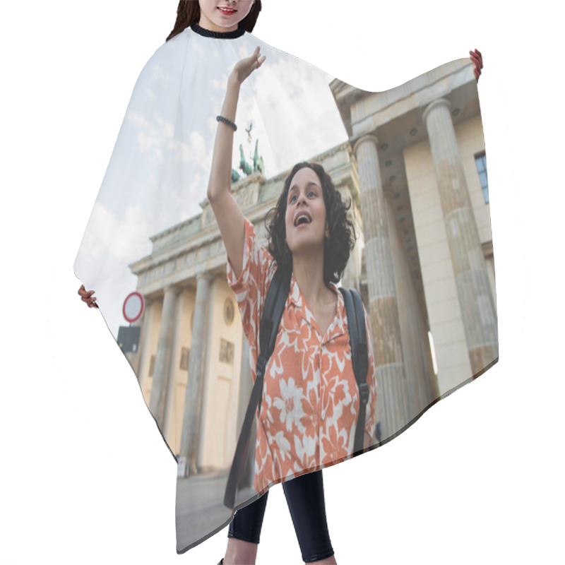 Personality  Curly Tourist With Backpack Waving Hand Near Brandenburg Gate In Berlin  Hair Cutting Cape