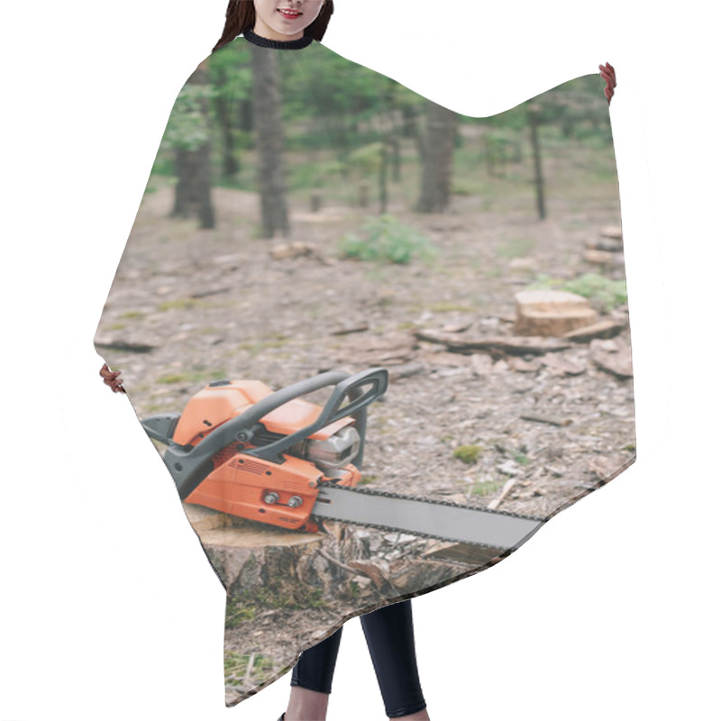 Personality  Electric, Sharp, Orange Chainsaw On Wood Stump In Forest  Hair Cutting Cape