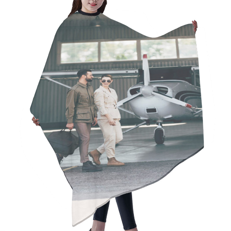 Personality  Stylish Man Carrying Bag And Walking With Girlfriend Near Hangar With Plane  Hair Cutting Cape