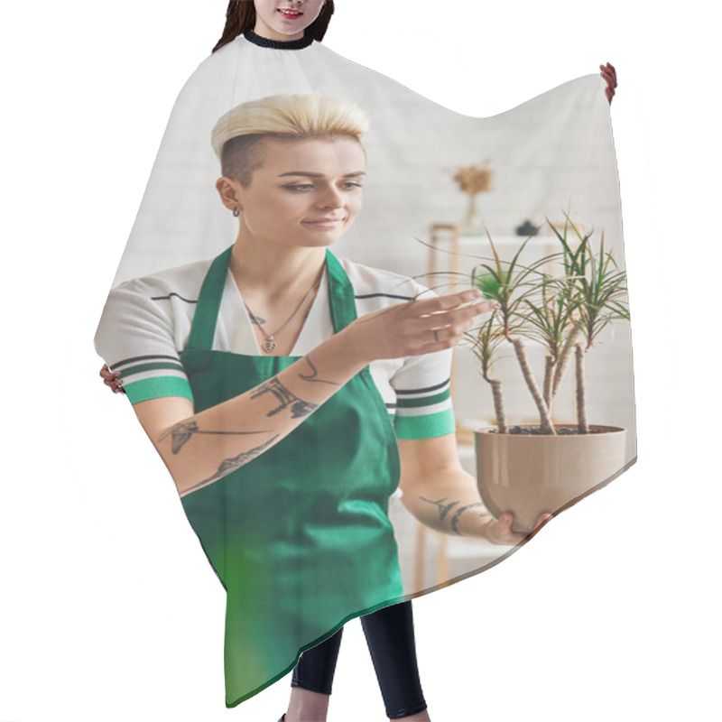 Personality  Eco-conscious Mindset, Positive And Tattooed Woman In Green Apron Touching Exotic Plant In Flowerpot While Standing In Modern Living Room, Sustainable Home Decor And Green Living Concept Hair Cutting Cape