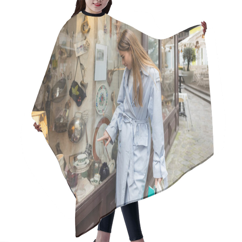 Personality  Young Woman In Trench Coat Standing With Shopping Bags And Pointing At Showcase Of Antique Shop In Vienna  Hair Cutting Cape